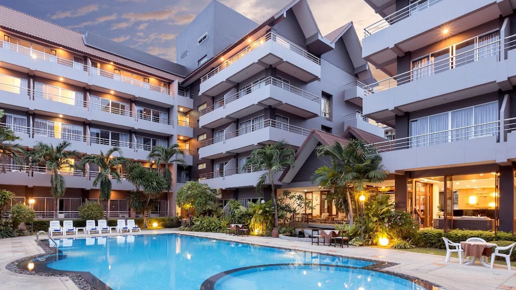 Hotel exterior and pool at dusk — The Holiday Resort Pattaya